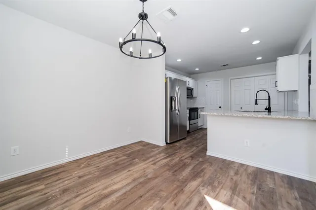 a view of a kitchen with a sink and dishwasher a refrigerator with wooden floor