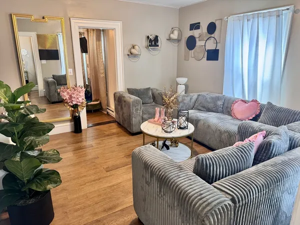 a living room with furniture and wooden floor