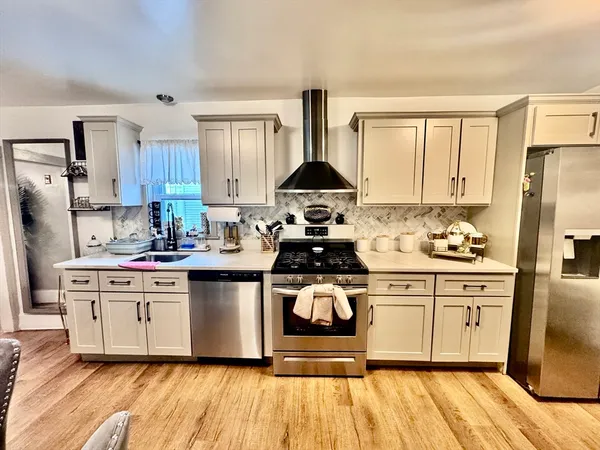 a kitchen with stainless steel appliances a stove a sink dishwasher and a refrigerator