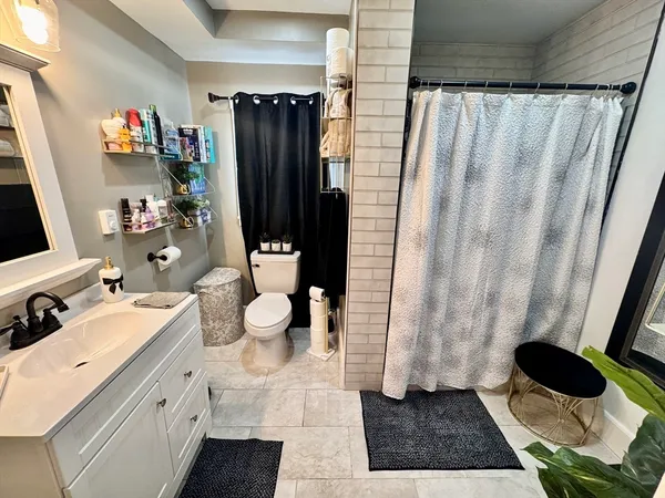 a bathroom with a sink a toilet and shower curtain