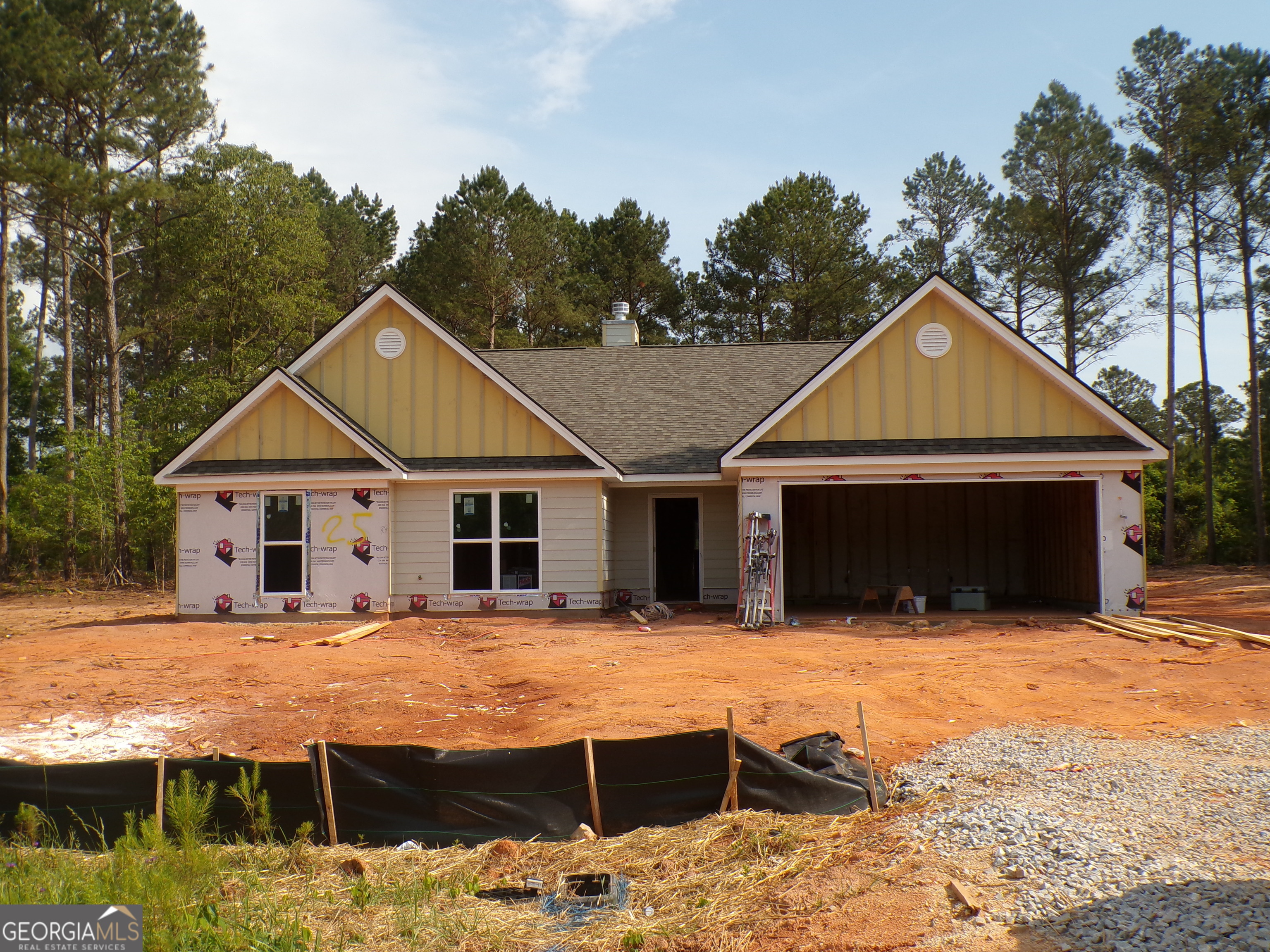 a front view of house with yard and trees in the background