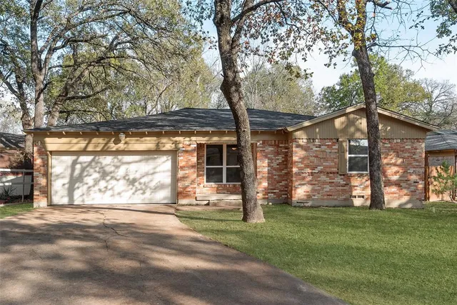 front view of a house with a large tree