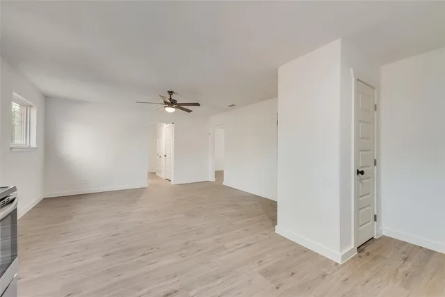 a view of a big room with wooden floor and windows