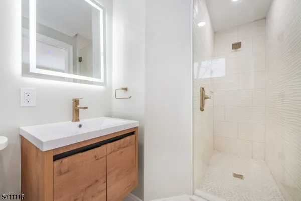 a bathroom with a sink a mirror and shower