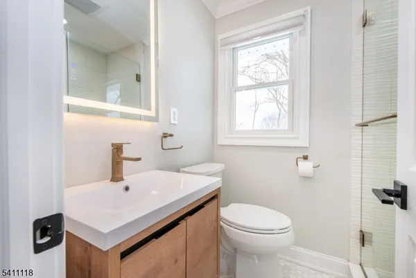 a bathroom with a sink a toilet and shower