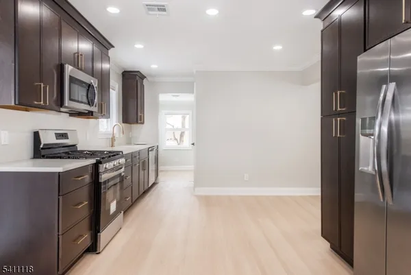 a kitchen with stainless steel appliances granite countertop a refrigerator a sink and a stove