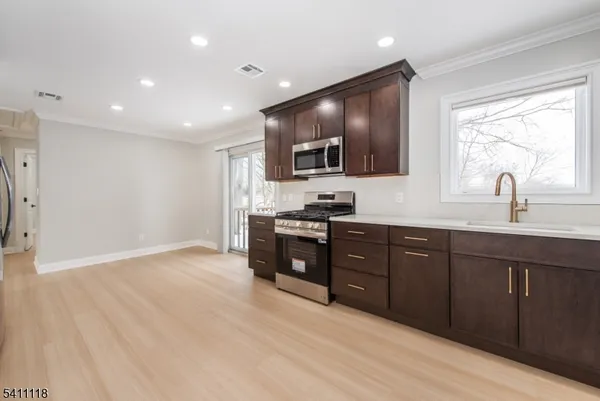 a kitchen with stainless steel appliances granite countertop a stove a sink and a microwave