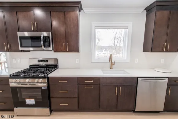 a kitchen with stainless steel appliances granite countertop a stove a sink and a microwave