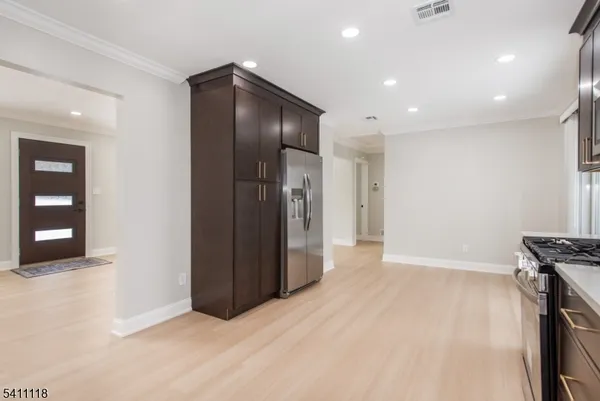 an empty room with wooden floor and entrance