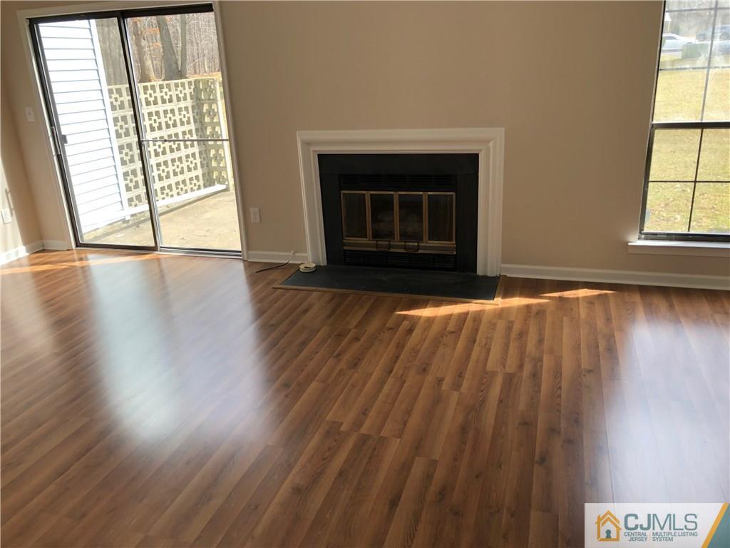 1804 Timber Oaks Road Edison, NJ 08820 - Photo 15 of 23 an empty room with wooden floor fireplace and windows