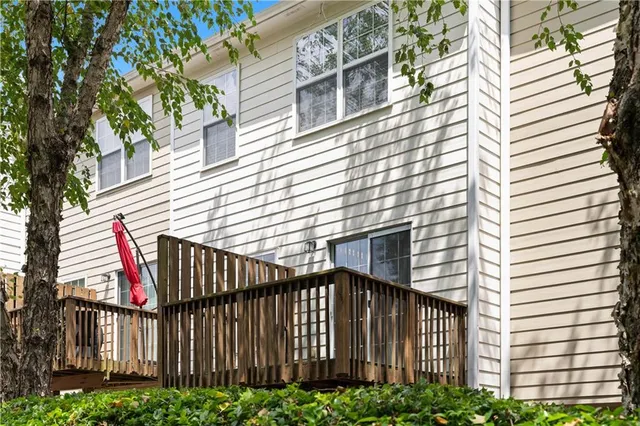 a view of a house with a small yard and wooden floor and fence