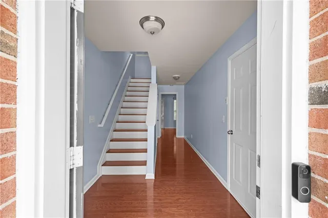 a view of a hallway with wooden floor and entryway