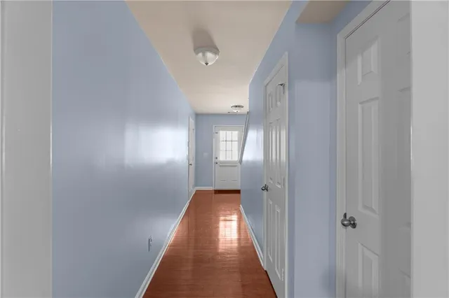 a view of a hallway with wooden floor and closet