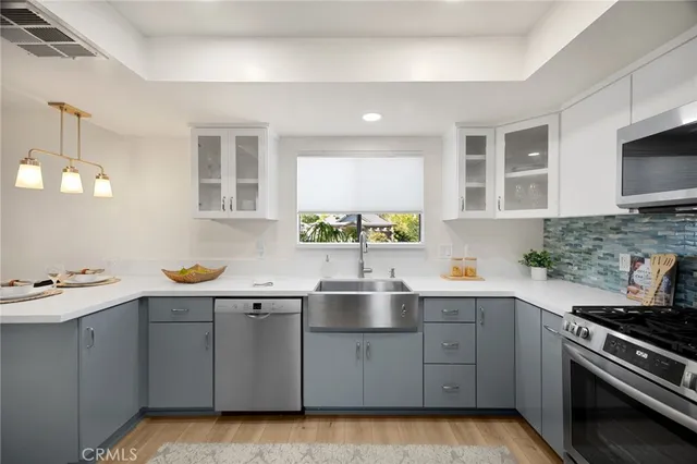 a kitchen with a sink cabinets and stainless steel appliances
