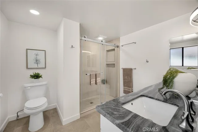 a bathroom with a granite countertop toilet a sink and a shower