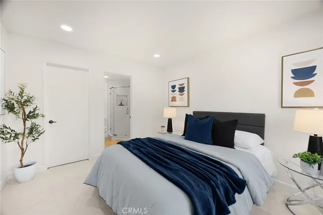 a bedroom with a large bed and a potted plant