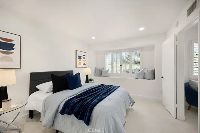 a bedroom with a bed and a large window