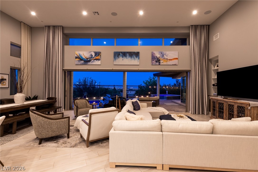 6014 Willow Ridge Court Las Vegas, NV 89135 - Photo 89 of 99 This living space features high ceilings, recessed lighting, and expansive sliding doors opening to an outdoor area.