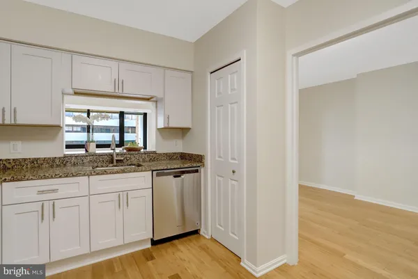 a kitchen with granite countertop white cabinets and a stove