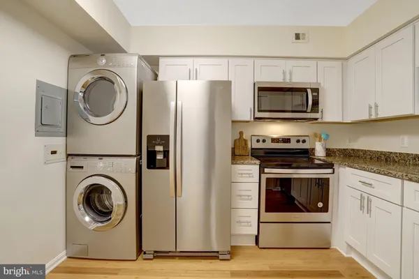 a kitchen with granite countertop a sink cabinets and wooden floor