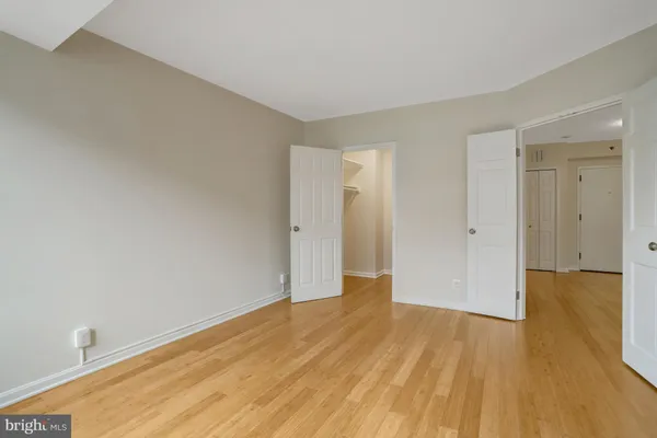 a view of an empty room with wooden floor and windows