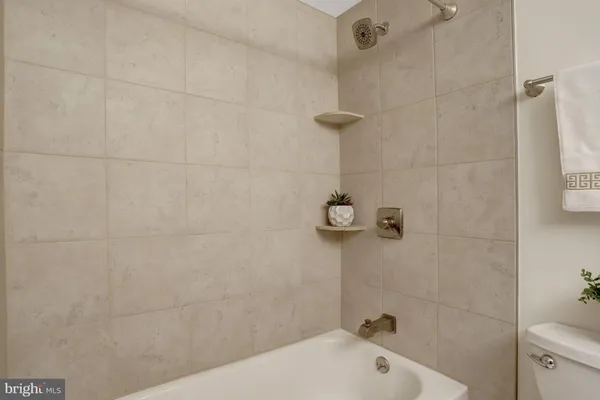 a bathroom with a granite countertop toilet sink and mirror