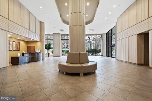 a living room with couches and kitchen view with wooden floor