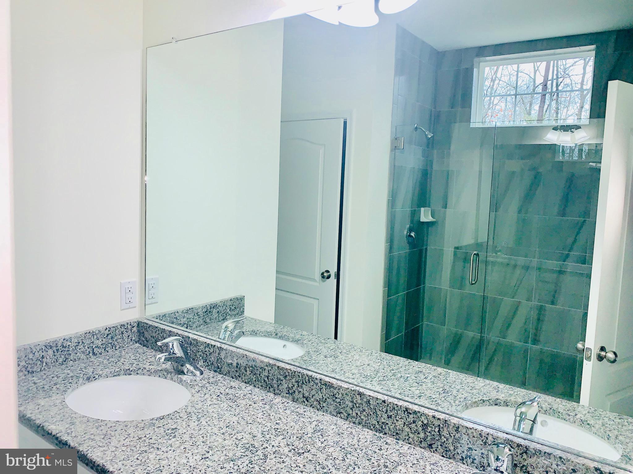 6 Patriots Way Georgetown, DE 19947 - Photo 8 of 35 a bathroom with a granite countertop shower sink and mirror
