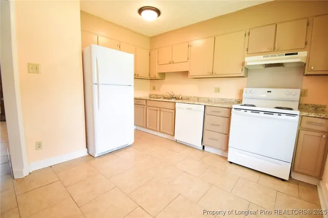 a kitchen with a refrigerator sink stove and cabinets