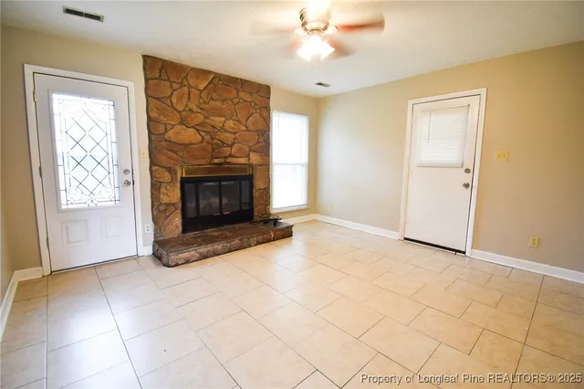 an empty room with windows and fireplace