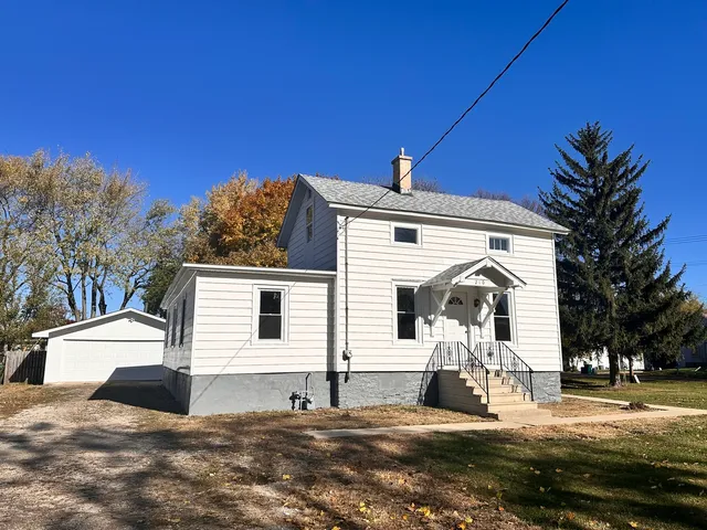 a view of a white house with a yard