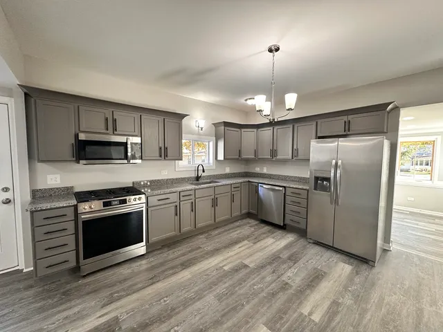 a kitchen with granite countertop stainless steel appliances and wooden cabinets