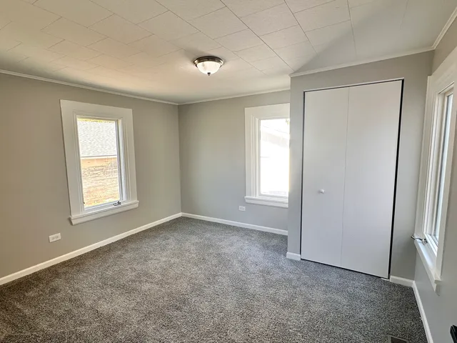 an empty room with windows and closet