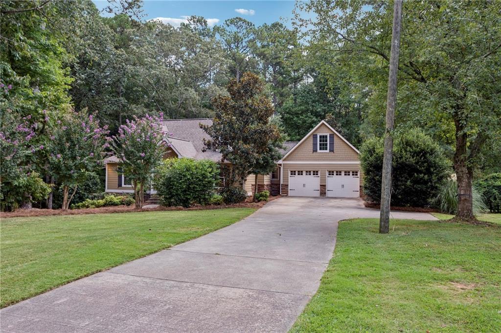 a front view of a house with a yard and trees