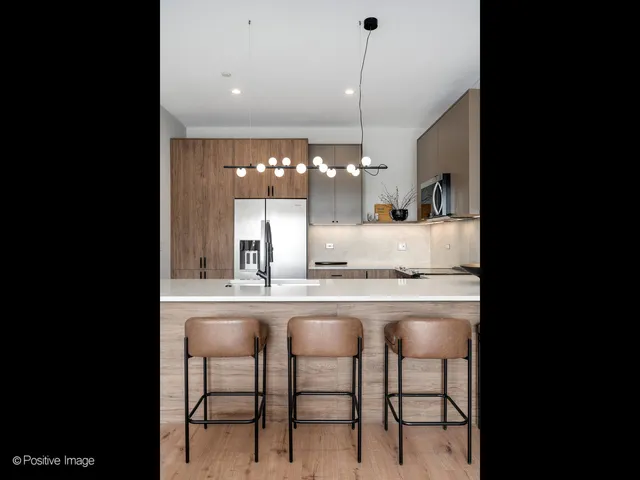 a kitchen with kitchen island granite countertop a table chairs sink and cabinets