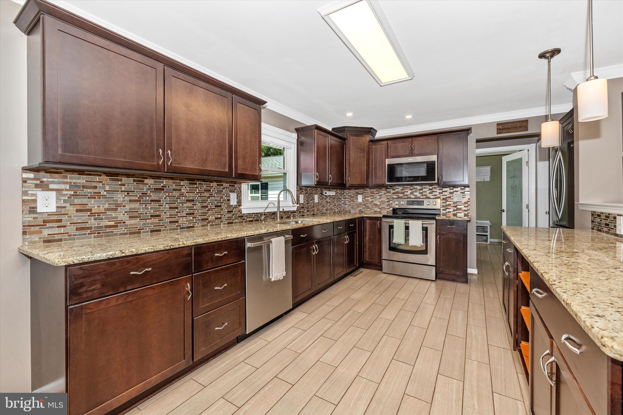 8107 Broadview Drive Frederick, MD 21701 - Photo 14 of 54 a kitchen with stainless steel appliances granite countertop wooden cabinets a sink and a stove