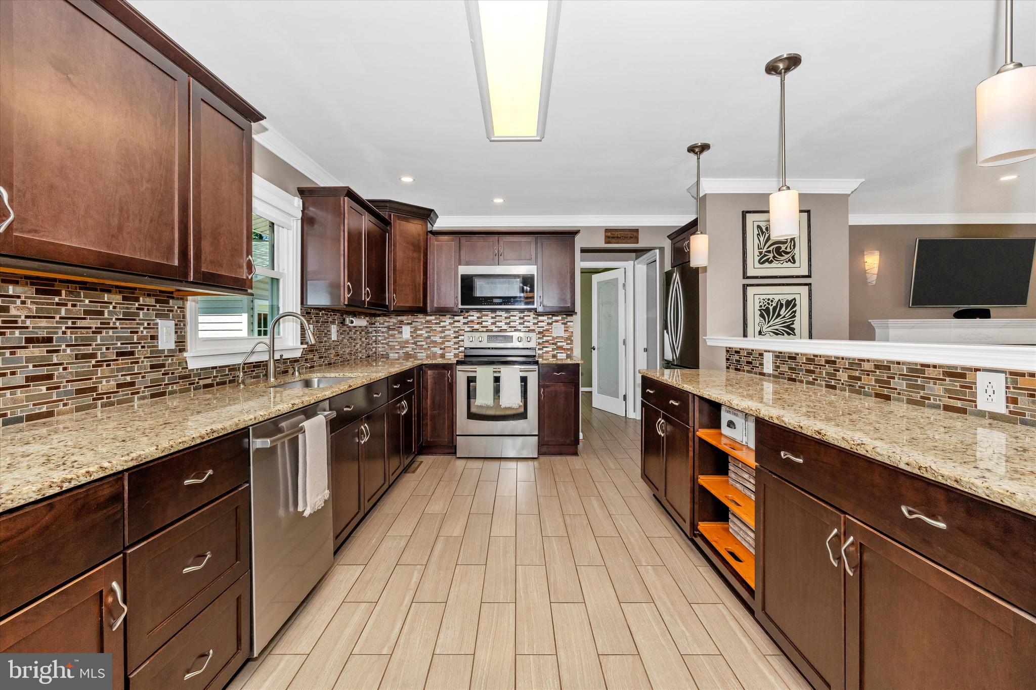 8107 Broadview Drive Frederick, MD 21701 - Photo 15 of 54 a large kitchen with stainless steel appliances granite countertop a stove a sink dishwasher and a microwave oven with large wooden cabinets