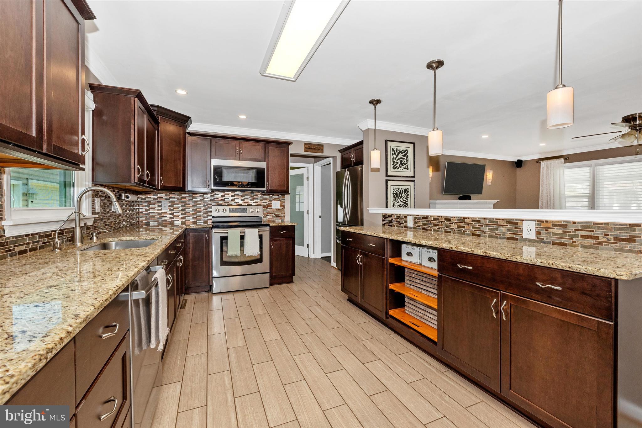8107 Broadview Drive Frederick, MD 21701 - Photo 16 of 54 a large kitchen with stainless steel appliances granite countertop a stove a sink and a wooden floors