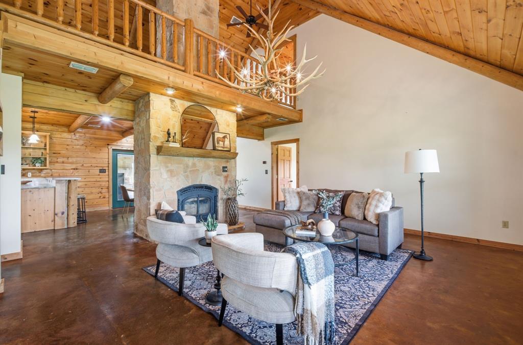 465 Emberson Ranch Road Pilot Point, TX 76258 - Photo 6 of 40 a living room with furniture a fireplace and a table
