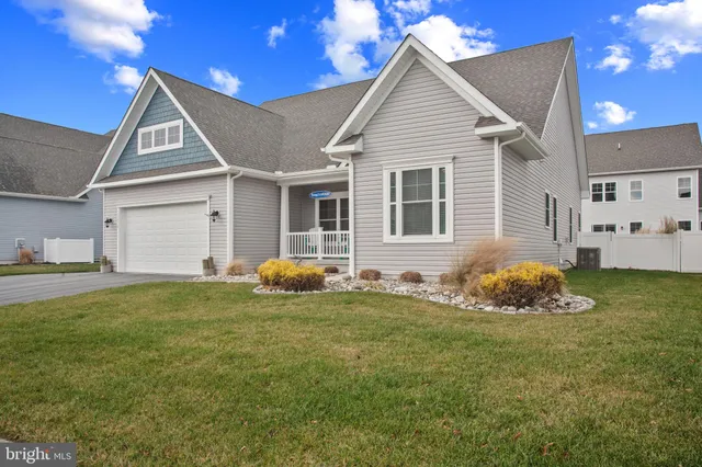 a front view of a house with a garden and yard