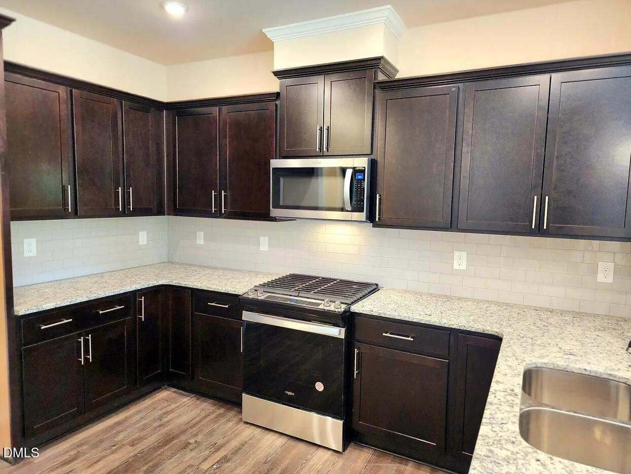237 Truss Bridge Street Fuquay-Varina, NC 27526 - Photo 5 of 20 a kitchen with granite countertop cabinets and black appliances