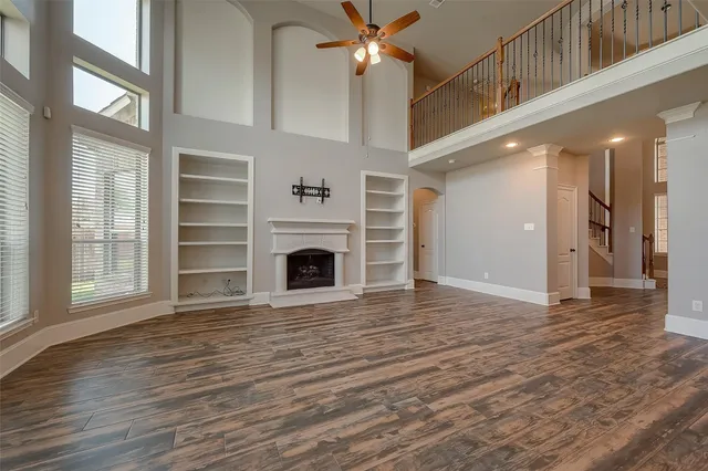 a view of empty room with wooden floor and fireplace