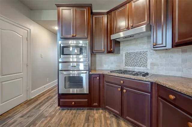 a kitchen with stainless steel appliances granite countertop a refrigerator a sink and a stove