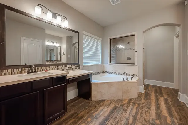 a spacious bathroom with a granite countertop double vanity sink and a mirror