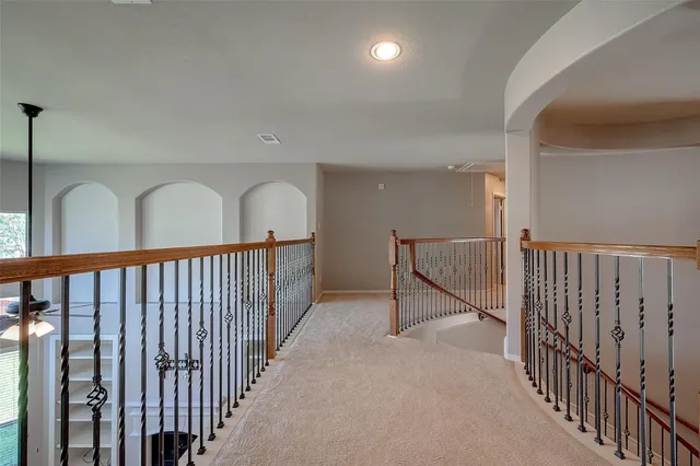 a view of staircase with railing and a chandelier