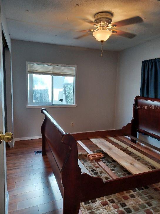 1286 Southwest Tropical Terrace Stuart, FL 34997 - Photo 22 of 28 a bedroom with a bed and a chandelier