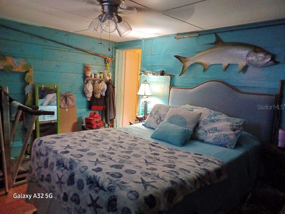 1286 Southwest Tropical Terrace Stuart, FL 34997 - Photo 26 of 28 a bedroom with a bed and a chandelier