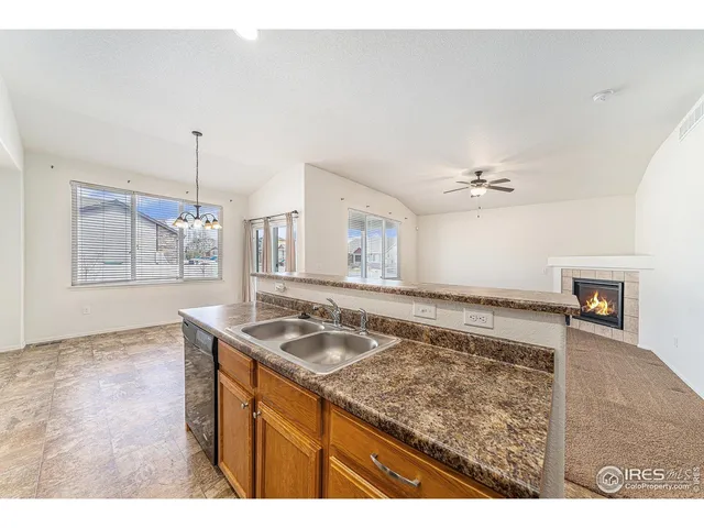 a kitchen with granite countertop a sink a stove and cabinets