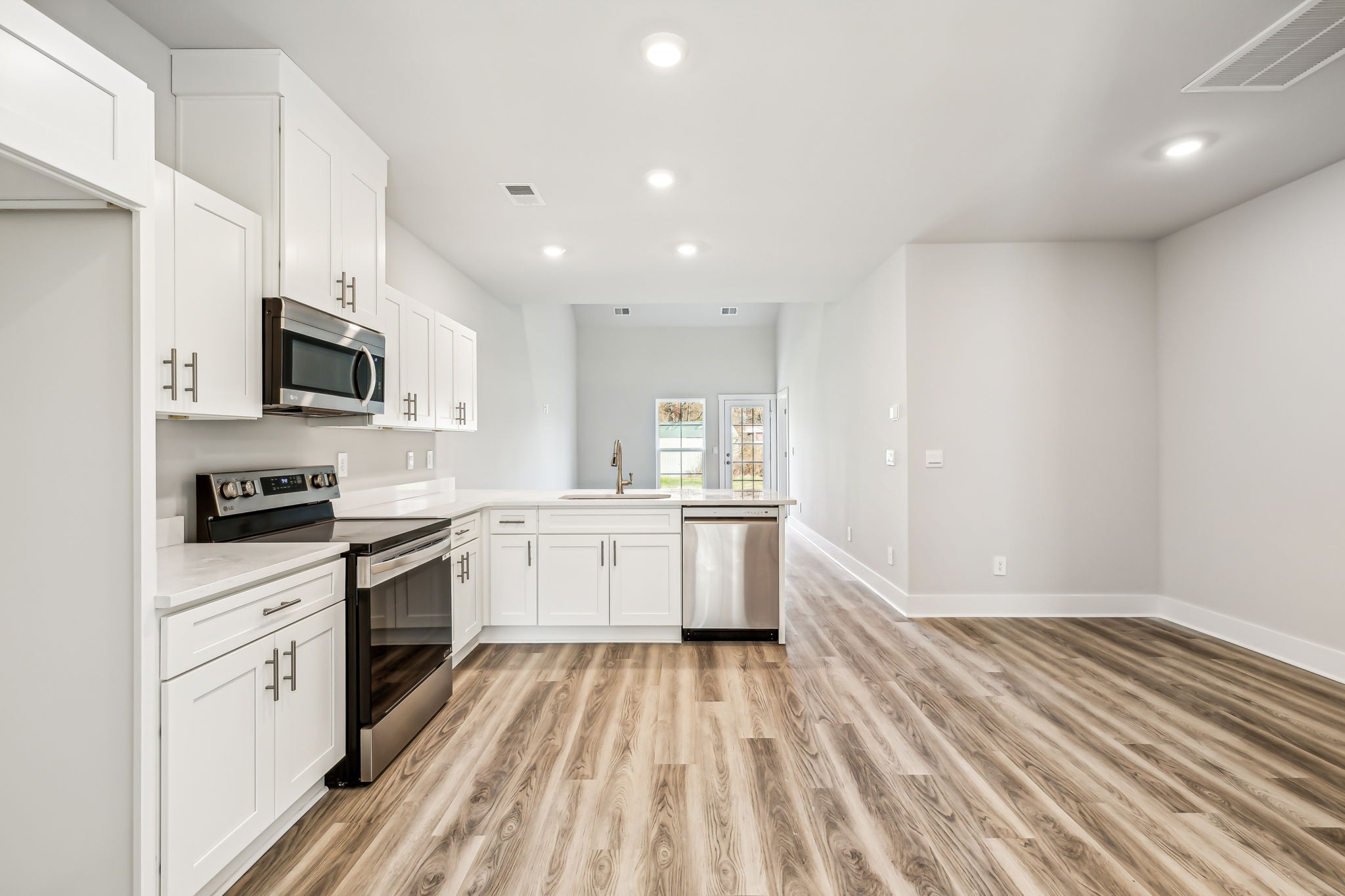 539 Tulip Springs Road Hermitage, TN 37076 - Photo 10 of 69 a large kitchen with granite countertop a stove top oven a sink dishwasher and white cabinets with wooden floor