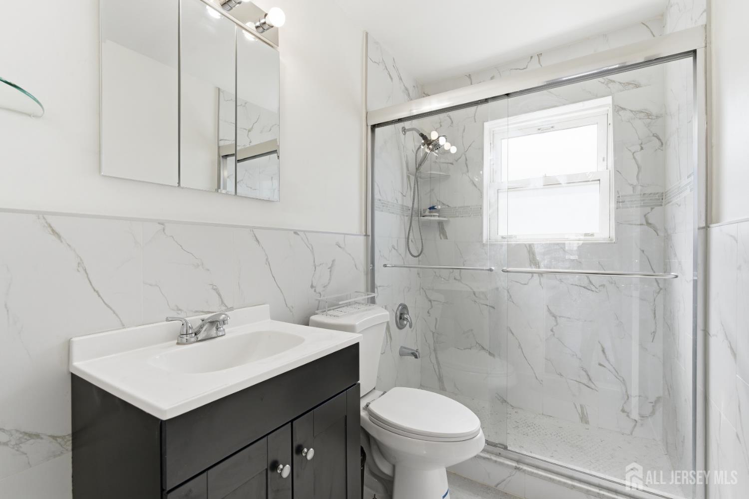 161 Evergreen Road, Unit 2A Edison, NJ 08837 - Photo 11 of 15 a bathroom with a sink toilet a mirror and shower